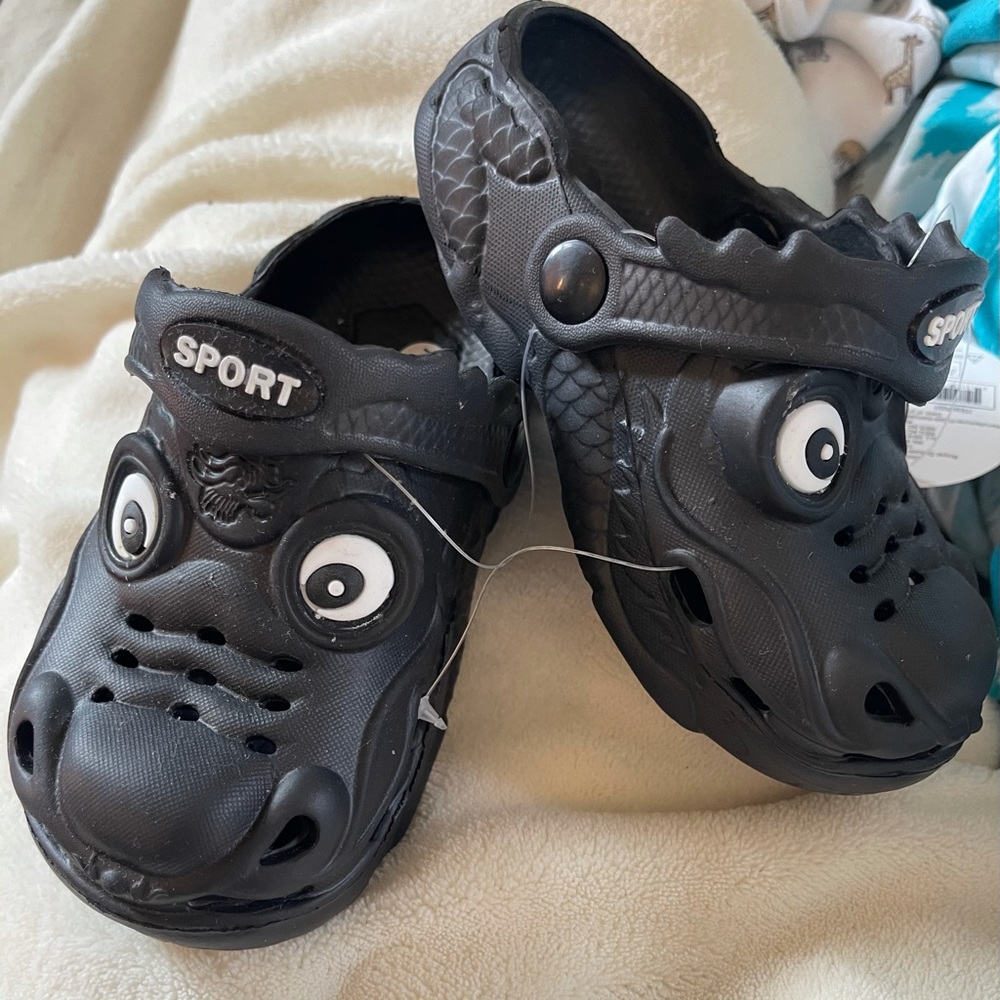 A black pair of dragon crocs